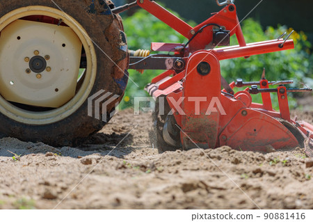 Cultivator for a mini-tractor for loosening the soil. Agricultural work. Excavation. Close-up 90881416