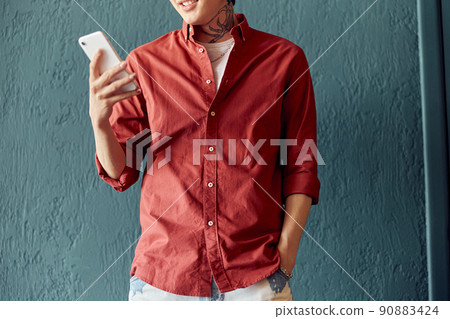 Happy guy holding smartphone and posing in studio 90883424