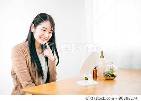 A woman who looks in the mirror in the room and has healed her rough skin (smile / mouth) 90888174
