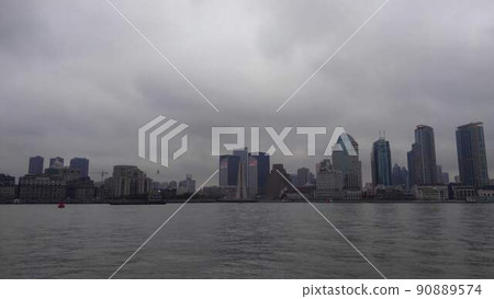 Skyscrapers lined up behind the old Western-style building on the right. A bird flying in bad weather looks small on the left 90889574