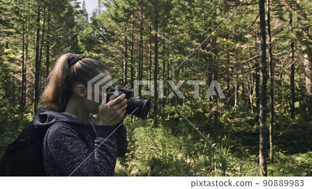 Traveler photographing scenic view in forest. One caucasian woman shooting nice magic look. Girl take photo video on dslr mirrorless camera. Traveler photographing scenic view in forest. One caucasian woman shooting nice magic look. Girl take photo video on dslr mirrorless camera. 90889983