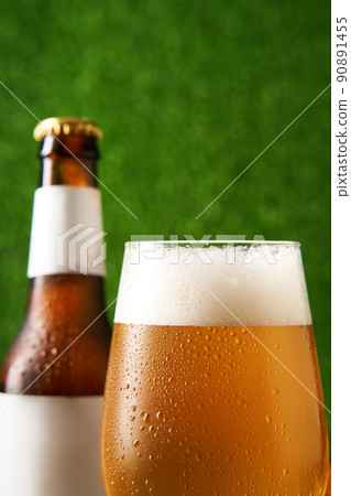 Bottle and glass of beer on the green grass background. 90891455