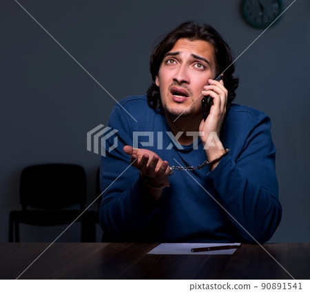 Young convict man sitting in dark room Young convict man sitting in dark room 90891541
