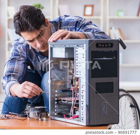 Computer repairman on wheelchair working 90891777