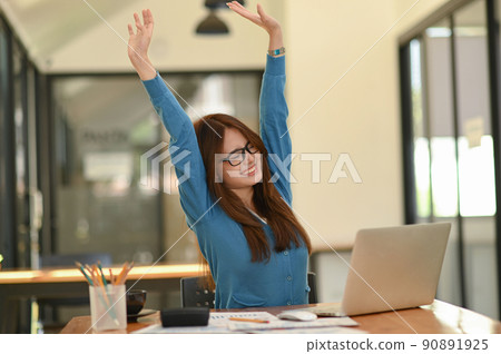 Woman stretches her arms when tired in the office, business woman relaxes, office syndrome. Woman stretches her arms when tired in the office, business woman relaxes, office syndrome. 90891925