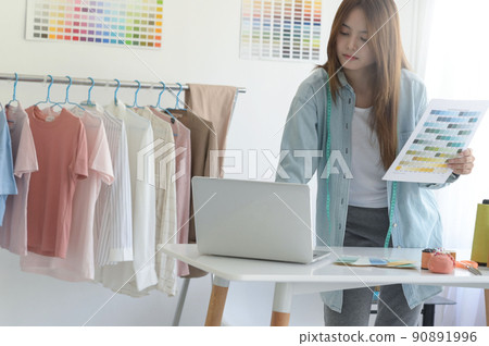 Young woman designer clothing, clothing designer workspace, clothing design accessories. 90891996