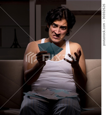 The young man calculating expences night at home The young man calculating expences night at home 90892626