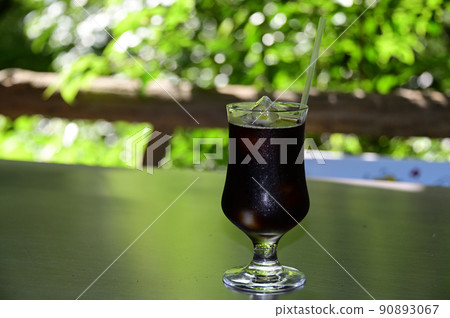 Iced coffee against the backdrop of green leaves Iced coffee against the backdrop of green leaves 90893067