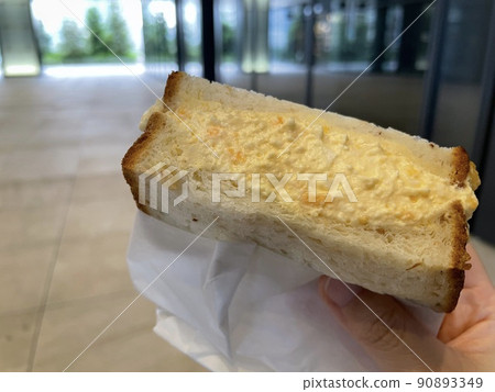 Egg sandwich - A fluffy egg sandwich made with toast, held by hand - Cafe - Breakfast Egg sandwich - A fluffy egg sandwich made with toast, held by hand - Cafe - Breakfast 90893349