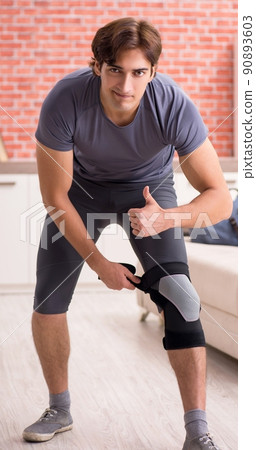 The young handsome man doing sport exercises at home 90893603
