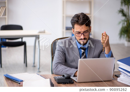 Young male employee unhappy with excessive work in the office Young male employee unhappy with excessive work in the office 90895262