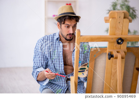 Young man enjoying painting at the studio 90895469