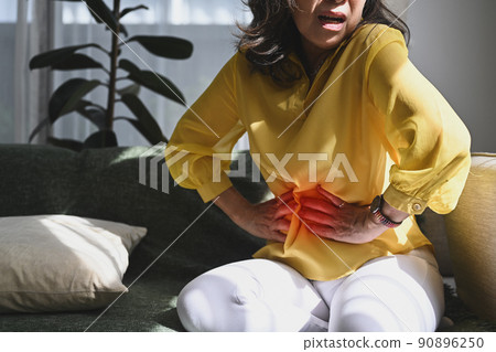 Unhappy middle aged lady touching belly, suffering from abdomen ache, symptoms gastrointestinal system disease, gut, digestion problems Unhappy middle aged lady touching belly, suffering from abdomen ache, symptoms gastrointestinal system disease, gut, digestion problems 90896250