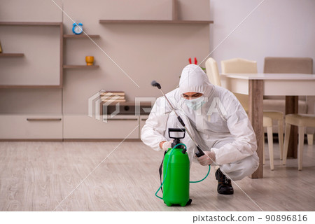 Young male contractor doing pest control at home Young male contractor doing pest control at home 90896816