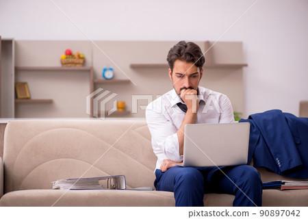 Young male employee working from home during pandemic Young male employee working from home during pandemic 90897042