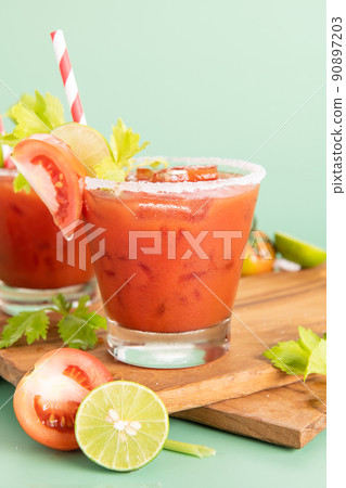 glass glass of tomato juice, lime with fresh bright bunch of tomatoes isolated on green background, green parsley. vegetable drink. glass glass of tomato juice, lime with fresh bright bunch of tomatoes isolated on green background, green parsley. vegetable drink. 90897203
