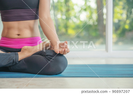 Woman practicing yoga, sitting in Padmasana exercise, lotus pose Woman practicing yoga, sitting in Padmasana exercise, lotus pose 90897207