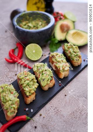 bruschetta with freshly made guacamole on grey concrete background bruschetta with freshly made guacamole on grey concrete background 90901614