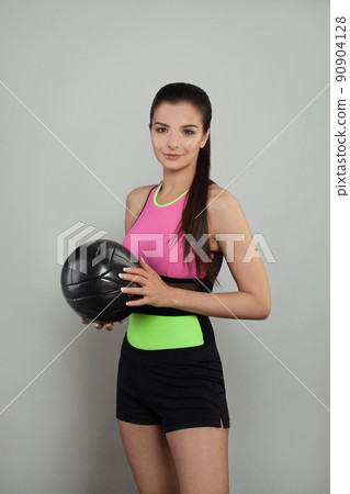 Beautiful woman holds a soccer ball. Attractive young brunette portrait 90904128