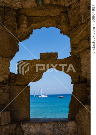 從希臘羅得島城牆的縫隙中看到的愛琴海和船隻 90904997
