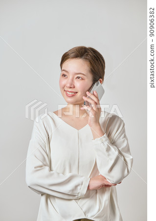 A young woman calling with a smartphone A young woman calling with a smartphone 90906382