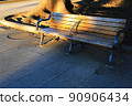 A bench colored by the contrast between the sunlight and shadows of the west sun 90906434