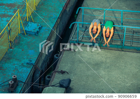 Two young beautiful twin sister dancing ballet in the city with ballet costume. urban sync dance. industrial street dancing. with special effect. synced posing. pointe ballet shoes and dress. Two young beautiful twin sister dancing ballet in the city with ballet costume. urban sync dance. industrial street dancing. with special effect. synced posing. pointe ballet shoes and dress. 90906659