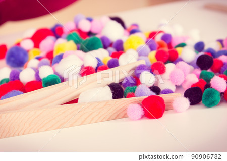 Small pompoms and wooden tongs. Development of kids motor skills, coordination and logical thinking Small pompoms and wooden tongs. Development of kids motor skills, coordination and logical thinking 90906782