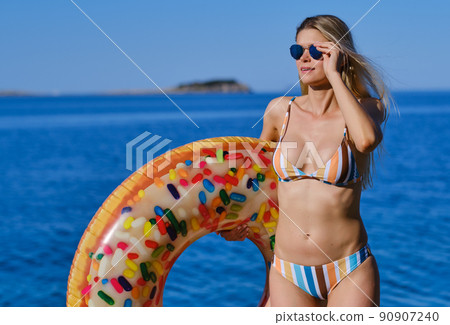 A woman on a rocky beach in Croatia. 90907240