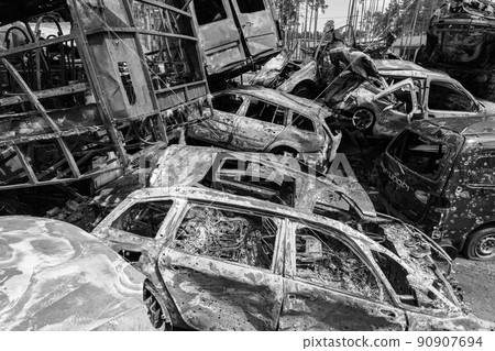 War-destroyed cars in Irpin, Bucha district, Ukraine, black and white 90907694