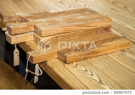 pile of wooden cutting boards on kitchen table 90907975