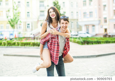 Happy smiling couple having fun in the street on summertime. . 90909765