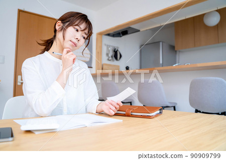 Young woman living room household account book Young woman living room household account book 90909799