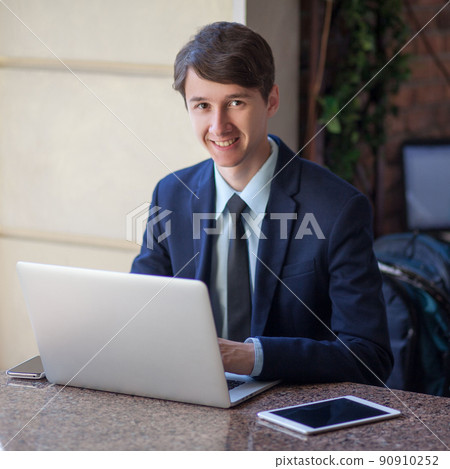 young man in business suit sitting in office and working young man in business suit sitting in office and working 90910252