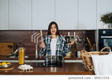 Young woman is preparing food in the kitchen. Prepare Food. Young woman is preparing food in the kitchen. Prepare Food. 90913358