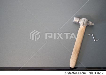 On the details of chipboard furniture there is a hammer and a hex key, top view. 90914647
