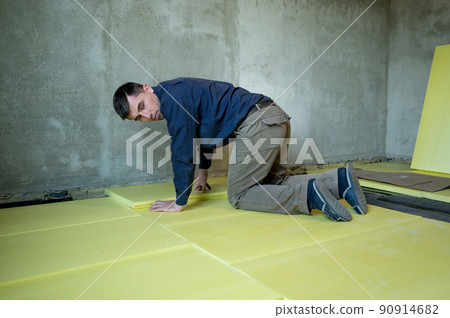 Installation of expanded polystyrene in the room for floor insulation, repair work alone, yellow expanded polystyrene. 90914682