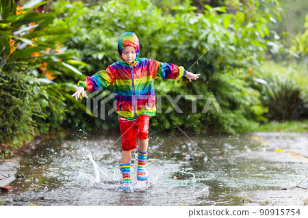 Kids in puddle in autumn rain. Waterproof wear 90915754