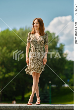 Cute woman in sundress in park 90916376
