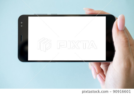 Mobile entertainment. Digital mockup. Online connection. Female hand holding smartphone with white blank screen isolated blue. 90916601