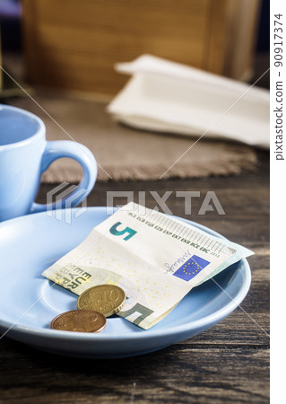 Restaurant tips in euro banknotes and coins Restaurant tips in euro banknotes and coins 90917374