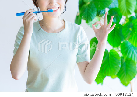 A young woman who marks OK while brushing her teeth A young woman who marks OK while brushing her teeth 90918124