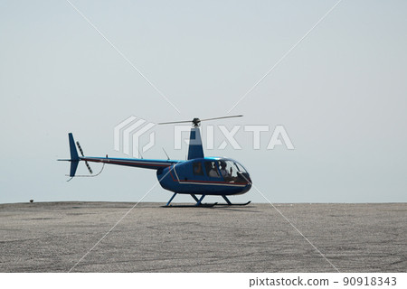 Blue helicopter flying in grey cloudy skies Blue helicopter flying in grey cloudy skies 90918343