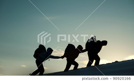 silhouette people climbers going forward mountain sunset. concept climbers with backpacks. teamwork. family trip mountains with backpacks winter sunset. campaign young successful winners. help hand. silhouette people climbers going forward mountain sunset. concept climbers with backpacks. teamwork. family trip mountains with backpacks winter sunset. campaign young successful winners. help hand. 90920166
