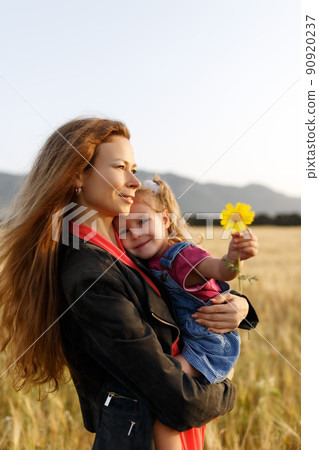 Portrait of a happy young mother and her lovely daughter playing and laughing in a field of wheat . Freedom concept. Portrait of a happy young mother and her lovely daughter playing and laughing in a field of wheat . Freedom concept. 90920237