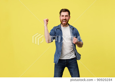 Excited happy man raise her hand up doing winner gesture clenching fist and shouting yes Excited happy man raise her hand up doing winner gesture clenching fist and shouting yes 90920284