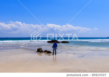 A woman walking on the beach of beautiful Kisami Ohama in Minamiizu 90924507