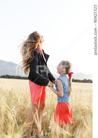Family fun. Mother and daughter jumping in the field 90925325