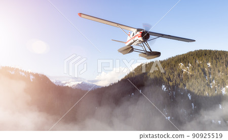 Seaplane flying over Canadian Mountain Nature Landscape. Seaplane flying over Canadian Mountain Nature Landscape. 90925519