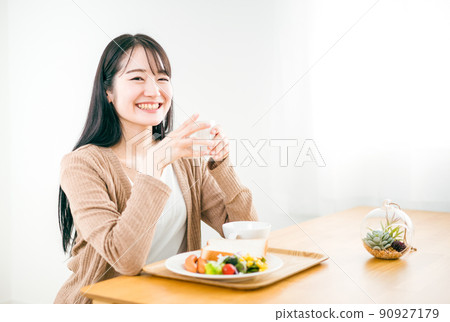 Woman eating breakfast (hot drink) 90927179